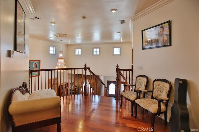 living area featuring crown molding and hardwood / wood-style flooring