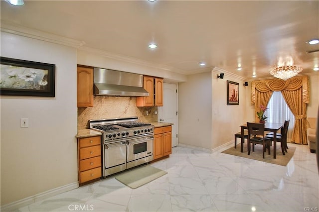 kitchen featuring tasteful backsplash, wall chimney range hood, range with two ovens, ornamental molding, and a chandelier