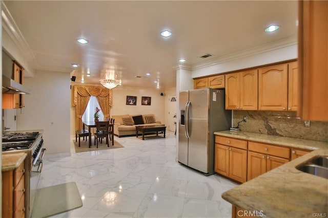 kitchen with wall chimney exhaust hood, stainless steel appliances, decorative backsplash, a notable chandelier, and crown molding