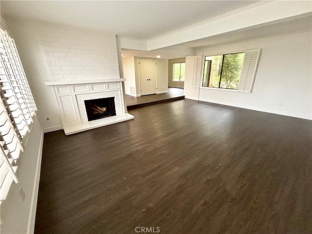 unfurnished living room with a brick fireplace and dark hardwood / wood-style flooring