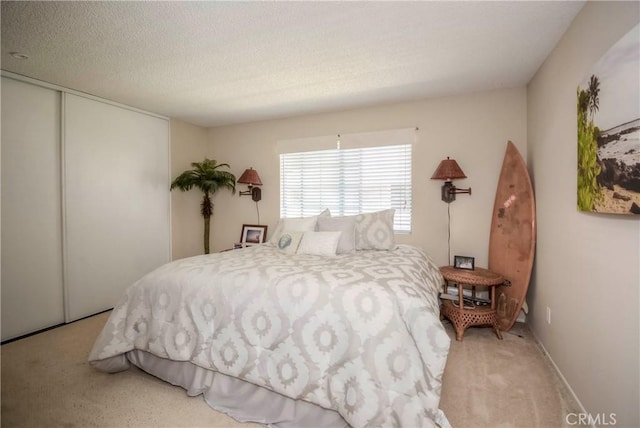 carpeted bedroom featuring a closet and a textured ceiling