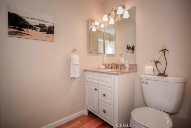 bathroom featuring toilet, vanity, and hardwood / wood-style flooring