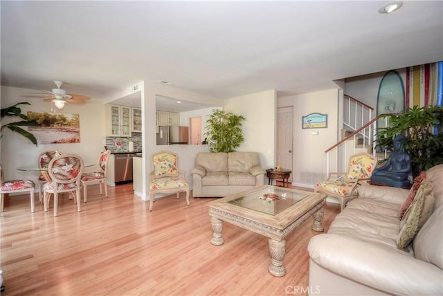 living room featuring ceiling fan and light hardwood / wood-style floors