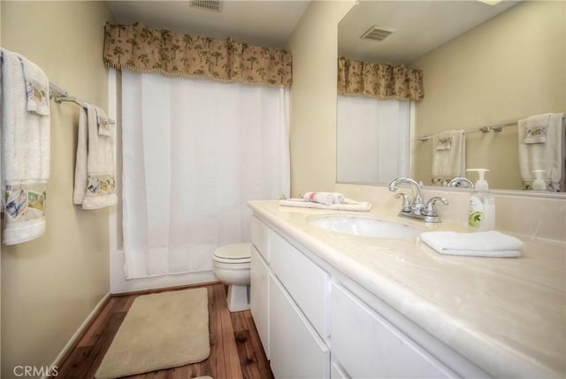 full bathroom featuring toilet, vanity, shower / tub combo, and hardwood / wood-style floors