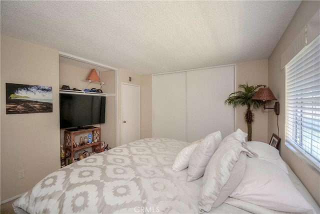 bedroom with a textured ceiling and a closet