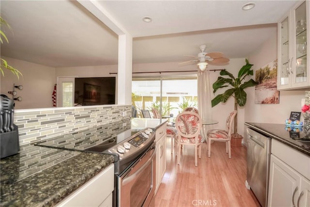 kitchen with appliances with stainless steel finishes, white cabinetry, light hardwood / wood-style floors, and tasteful backsplash