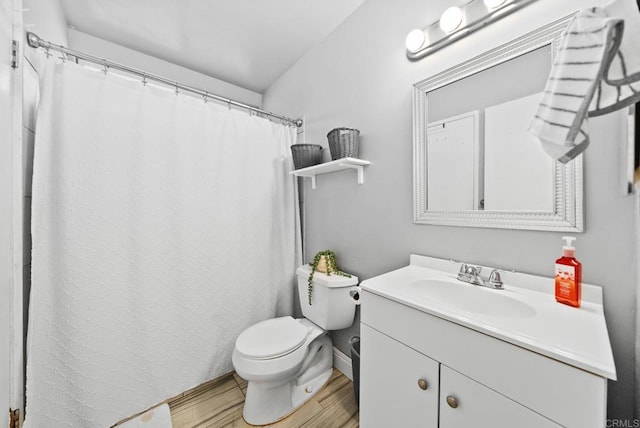 bathroom with toilet, vanity, and hardwood / wood-style floors