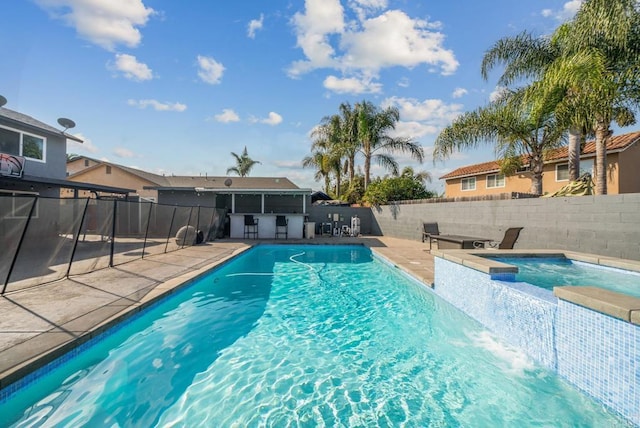 view of swimming pool with a hot tub and a patio area