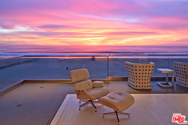 patio terrace at dusk with a water view and a balcony