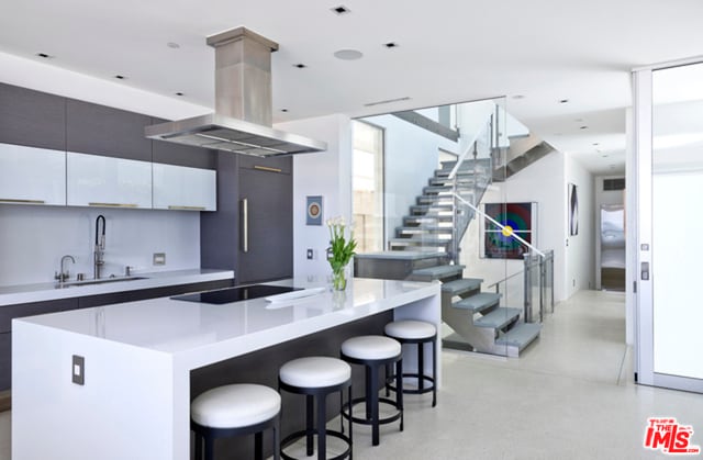 kitchen with island exhaust hood, black electric cooktop, a kitchen island, white cabinets, and sink