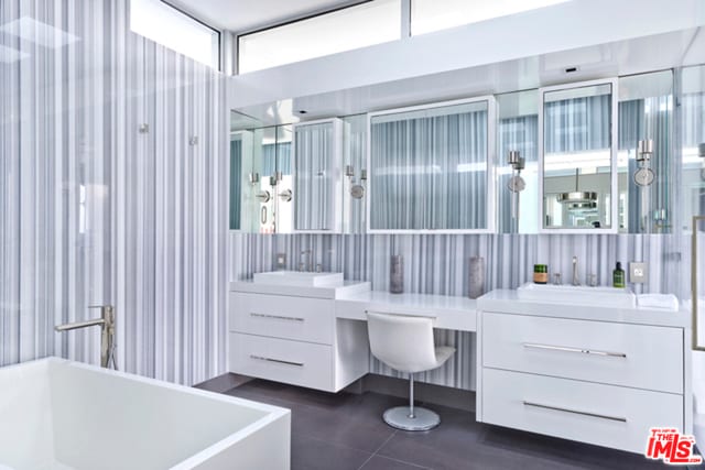 bathroom featuring vanity, tile patterned flooring, and a bathing tub