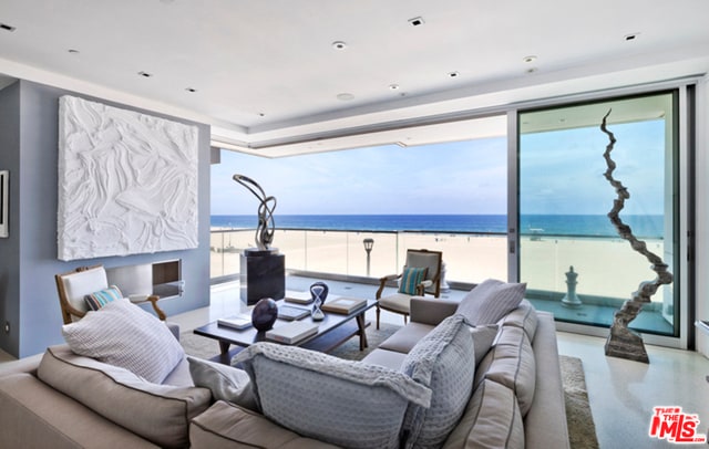 living room featuring a water view and a beach view