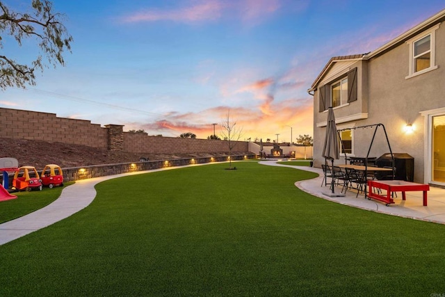 yard at dusk with a patio area