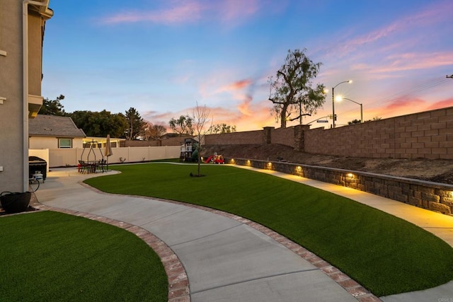 yard at dusk with a patio area