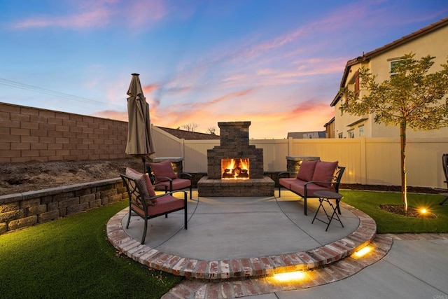 patio terrace at dusk featuring exterior fireplace