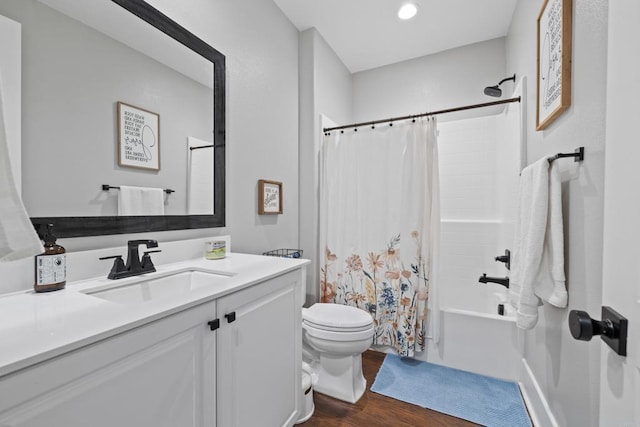 full bathroom featuring hardwood / wood-style flooring, vanity, shower / bath combination with curtain, and toilet