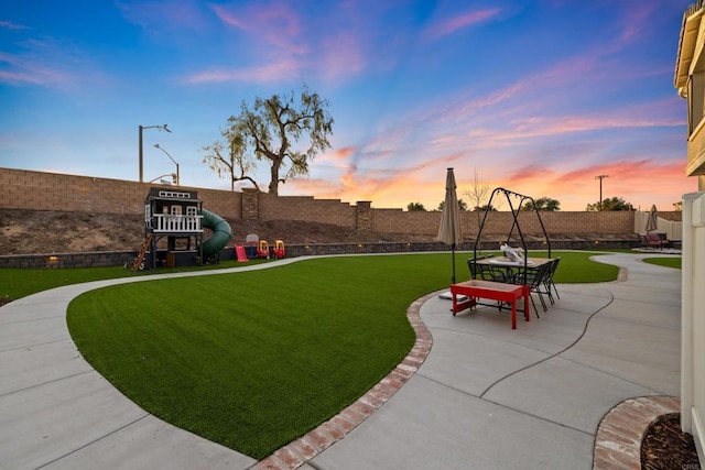 yard at dusk featuring a patio area