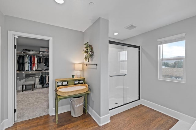 bathroom featuring an enclosed shower and wood-type flooring