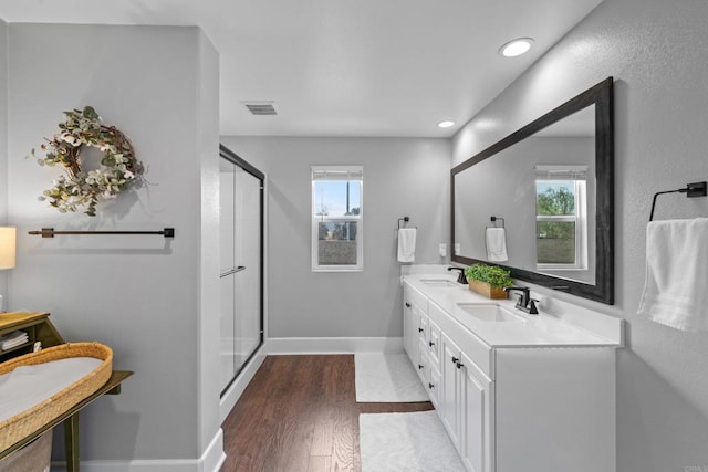 bathroom with hardwood / wood-style flooring, vanity, and a shower with shower door