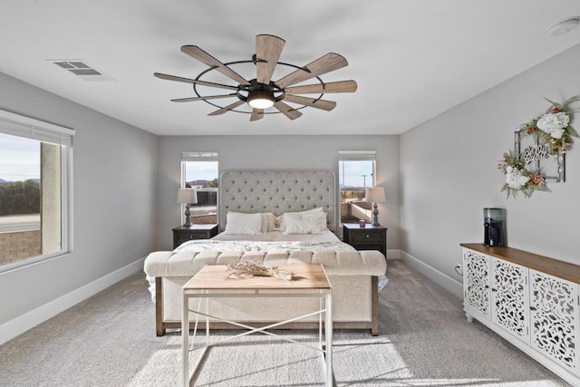 carpeted bedroom featuring ceiling fan and multiple windows