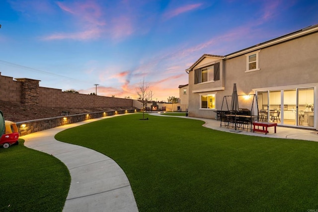 yard at dusk featuring a patio area