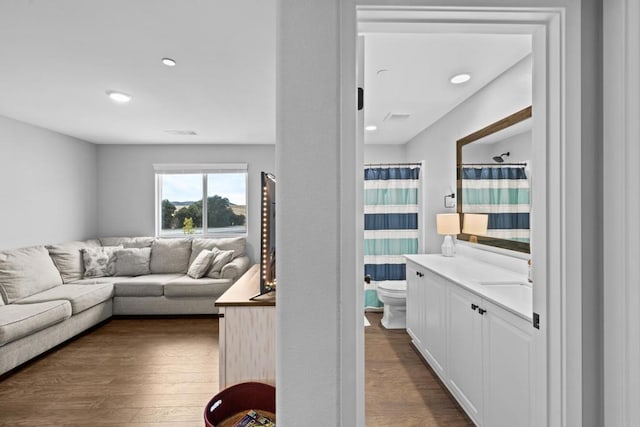 living room with dark hardwood / wood-style flooring and sink