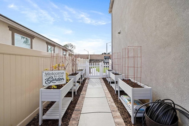 view of patio featuring a garden and fence