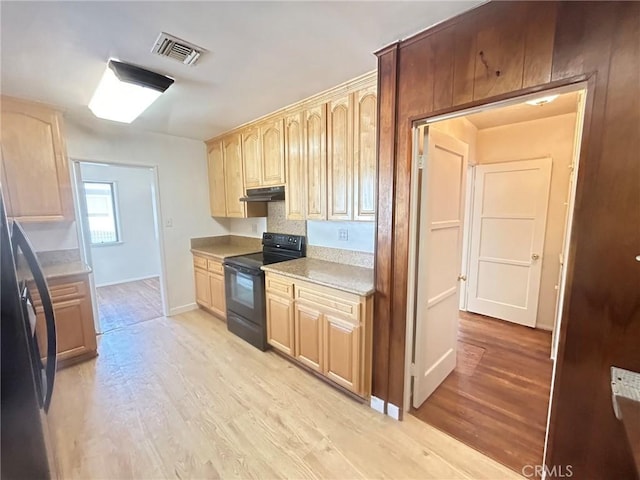 kitchen with electric range, light brown cabinets, and light hardwood / wood-style flooring