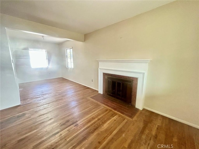 unfurnished living room featuring a fireplace and wood-type flooring