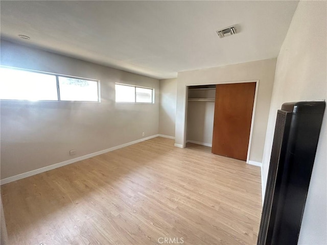 unfurnished bedroom with a closet and light hardwood / wood-style flooring