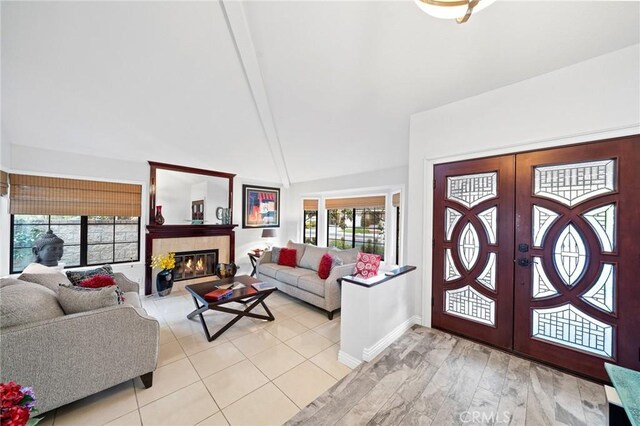 foyer entrance with a healthy amount of sunlight, french doors, and a tiled fireplace