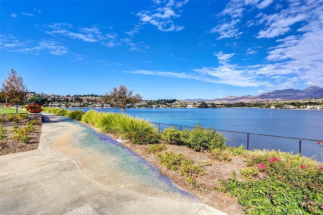 property view of water with a mountain view and fence