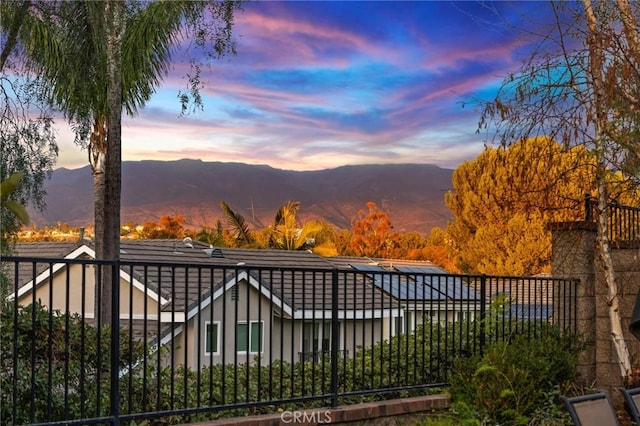 exterior space featuring solar panels, a mountain view, and fence