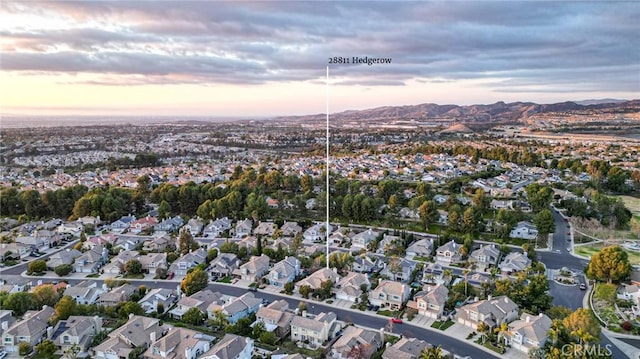 aerial view at dusk featuring a residential view and a mountain view