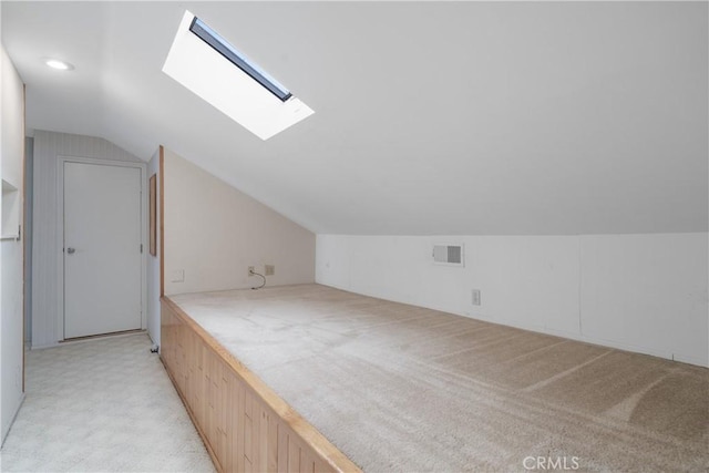 bonus room featuring lofted ceiling with skylight, visible vents, and light colored carpet