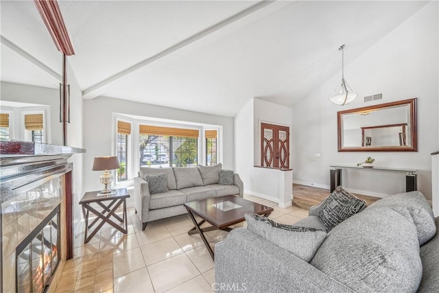 living room with visible vents, baseboards, beamed ceiling, light tile patterned floors, and high vaulted ceiling