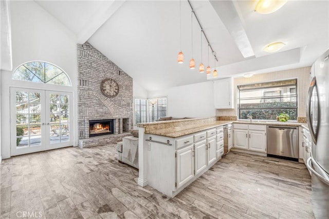 kitchen with plenty of natural light, a peninsula, stainless steel appliances, and a fireplace