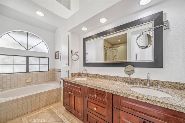 bathroom with a sink, a garden tub, recessed lighting, and double vanity