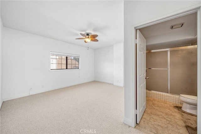 unfurnished bedroom featuring a closet, light carpet, baseboards, and a ceiling fan