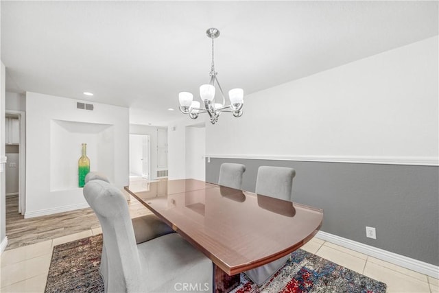 dining space with light tile patterned floors, baseboards, visible vents, recessed lighting, and a notable chandelier