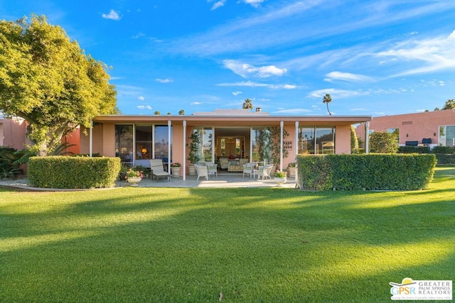 rear view of property featuring a yard and a patio