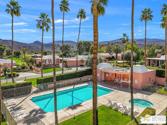 view of swimming pool featuring a patio area, a mountain view, and a community hot tub