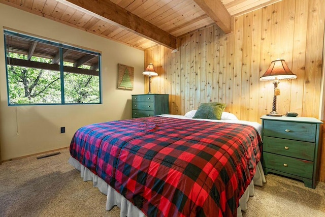 carpeted bedroom with wood ceiling, beam ceiling, and wooden walls