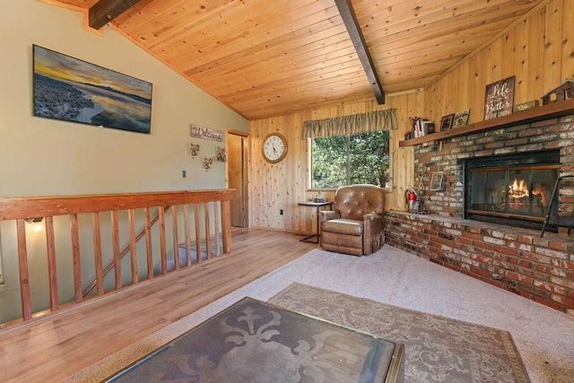 carpeted living room featuring a brick fireplace, lofted ceiling with beams, wood ceiling, and wooden walls