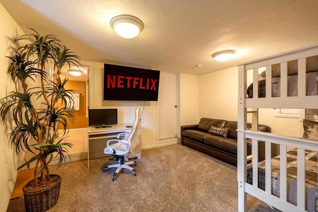 office with built in desk, light colored carpet, and a textured ceiling