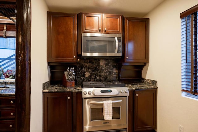 kitchen featuring decorative backsplash, stainless steel appliances, and dark stone counters