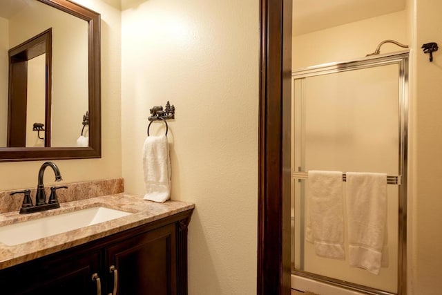 bathroom with a shower with door and vanity