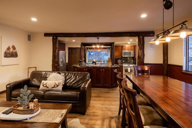 living room featuring light wood-type flooring and beamed ceiling