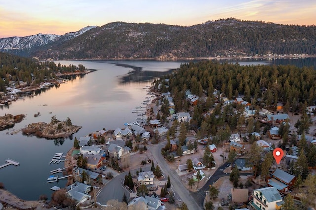 aerial view at dusk featuring a water and mountain view