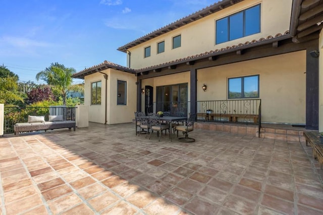 back of house featuring an outdoor living space and a patio area